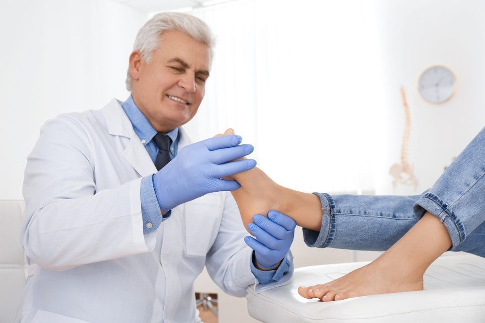 A Doctor is Examining a Patient's Foot in a Hospital a Doctor — Maitland Central Podiatry in Maitland NSW