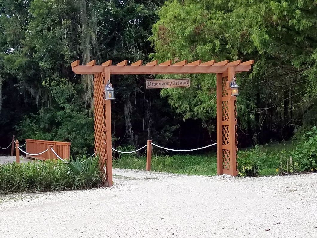 a wooden archway with a sign that says discovery island