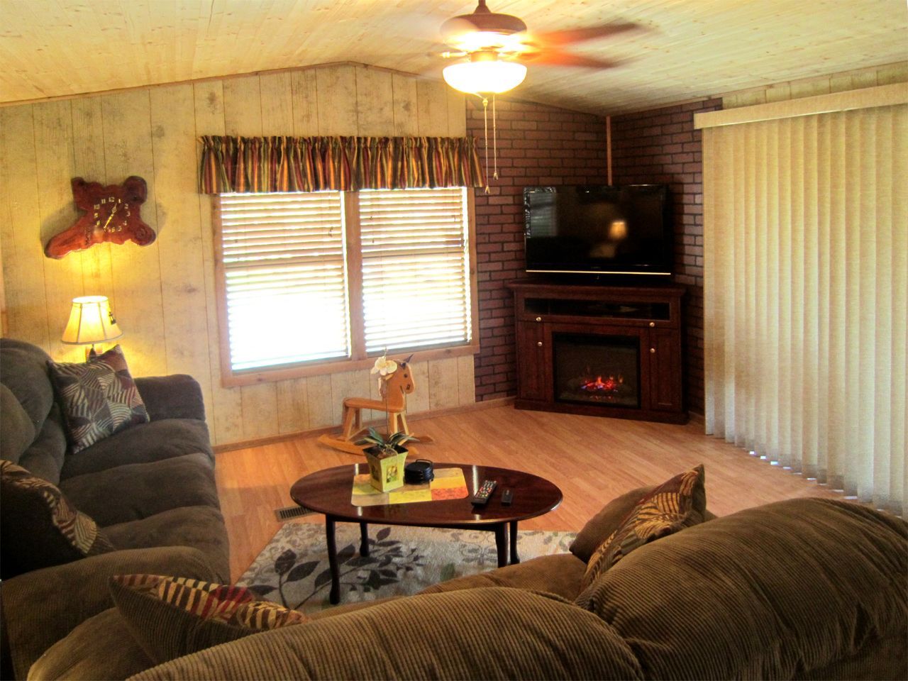 a living room with a fireplace and a ceiling fan