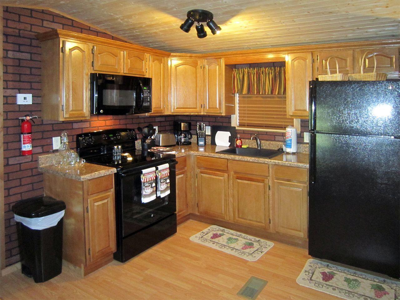 a kitchen with wooden cabinets and a black refrigerator