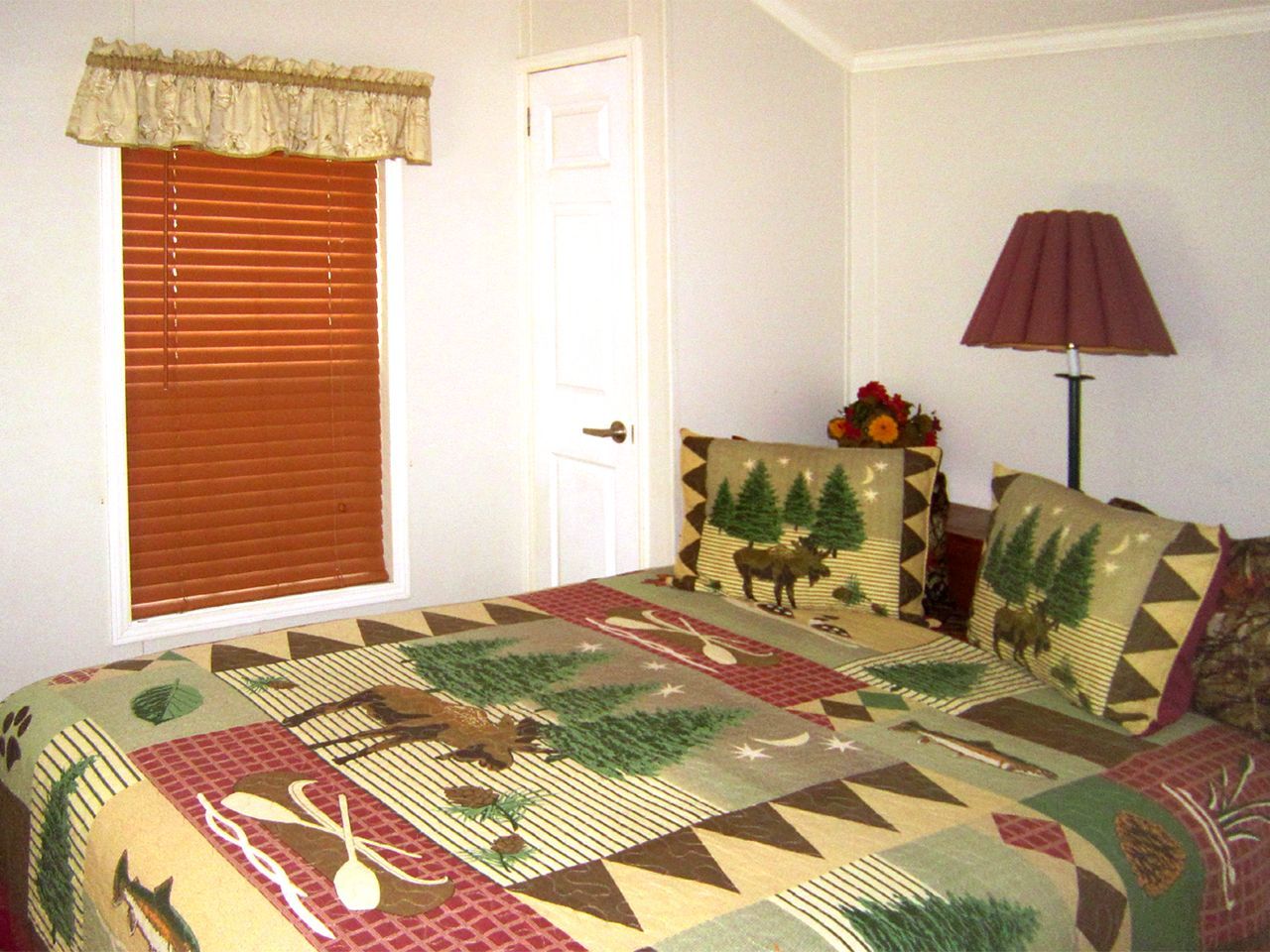a bedroom with a bed a lamp and a window