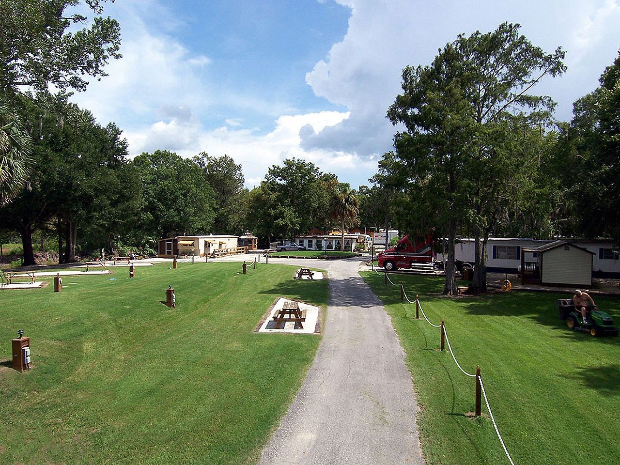 a dirt road going through a park with a lot of trees