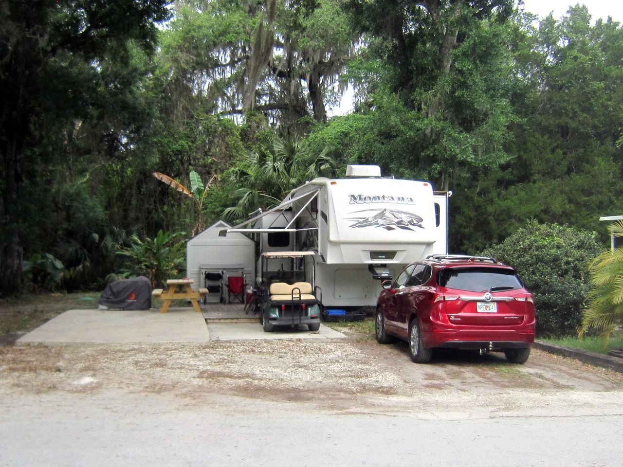 a red suv is parked in front of a rv