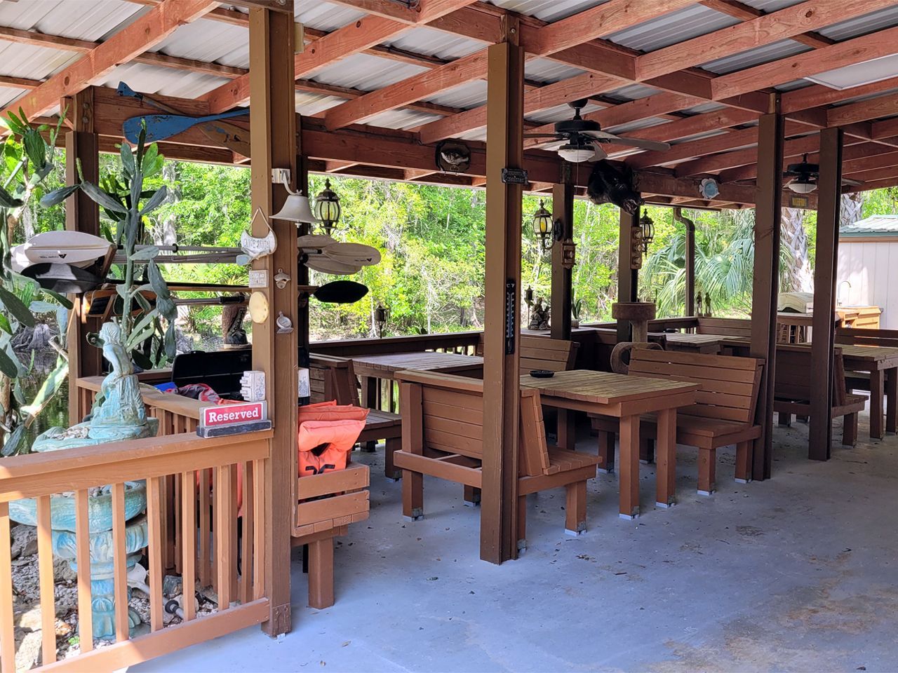 a covered area with tables and benches under a roof