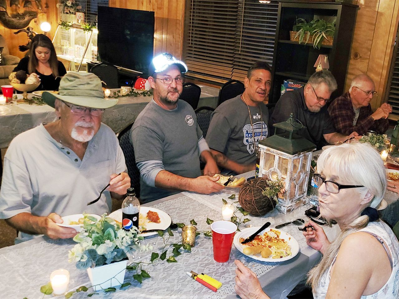 a group of people are sitting at a table eating food