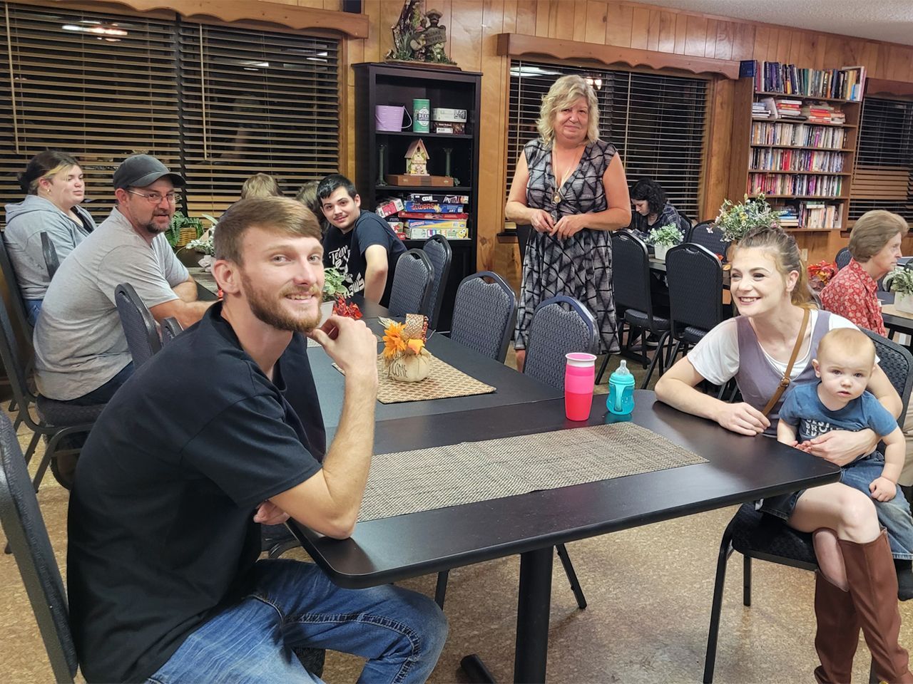 a group of people are sitting at tables in a restaurant .