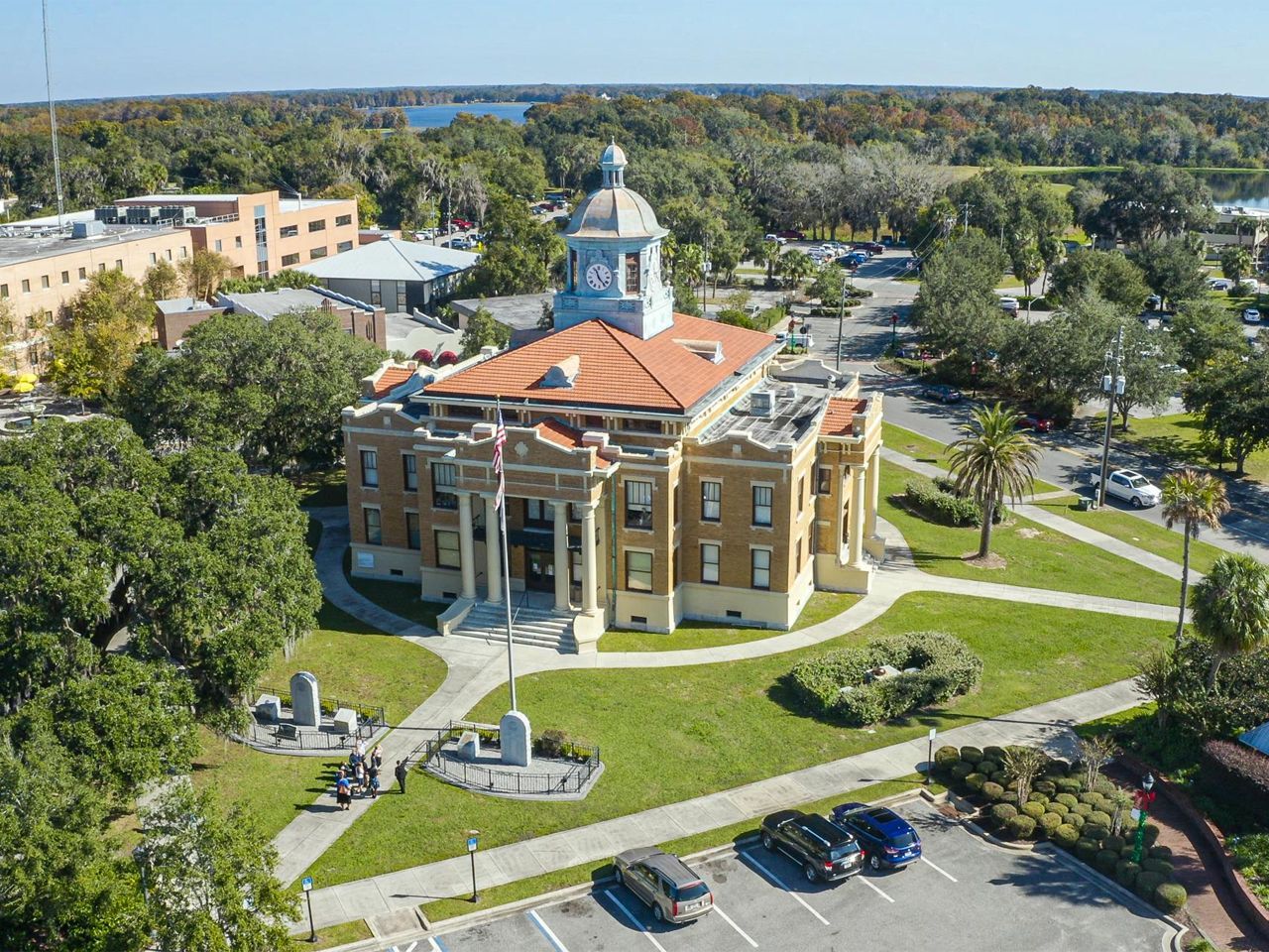 an aerial view of a courthouse surrounded by trees and a parking lot .