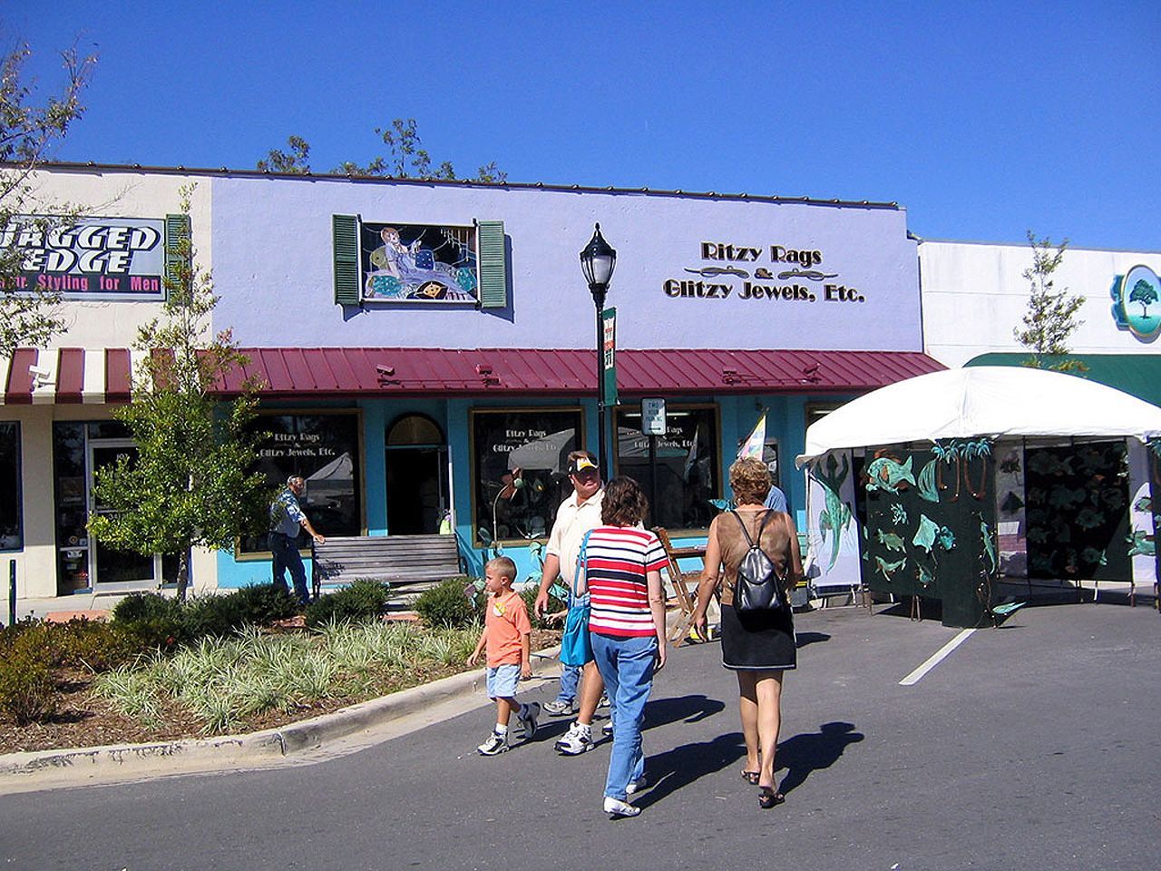 a group of people walking in front of a store called jagged edge