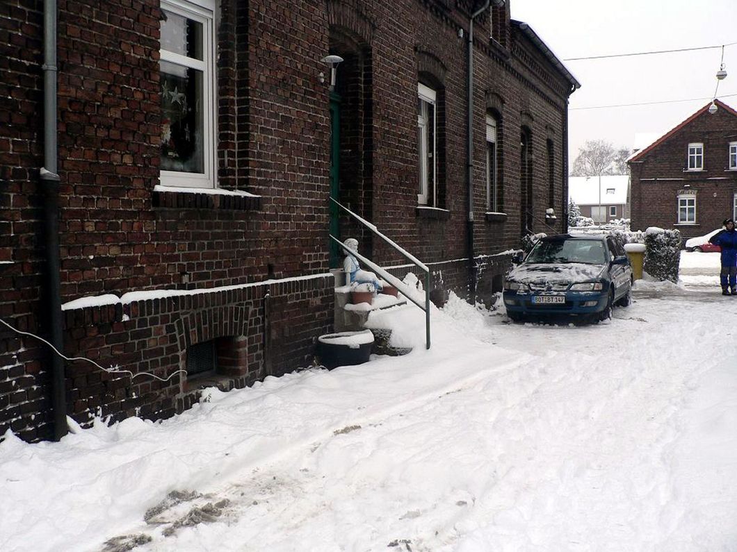 a brick building with a blue car parked in front of it