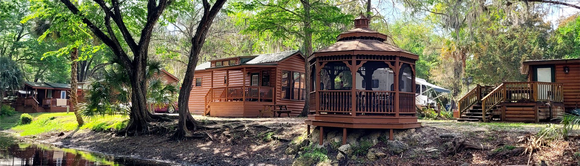 a gazebo is sitting in the middle of a forest next to a house .