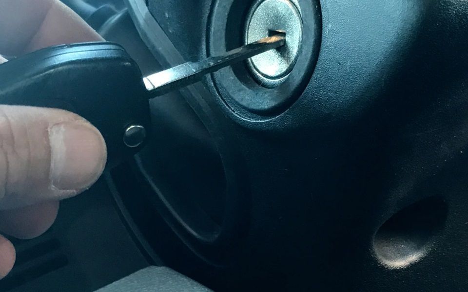 A car key going into the ignition keyhole.