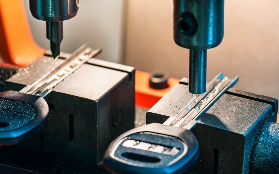 Two new car keys being cut.