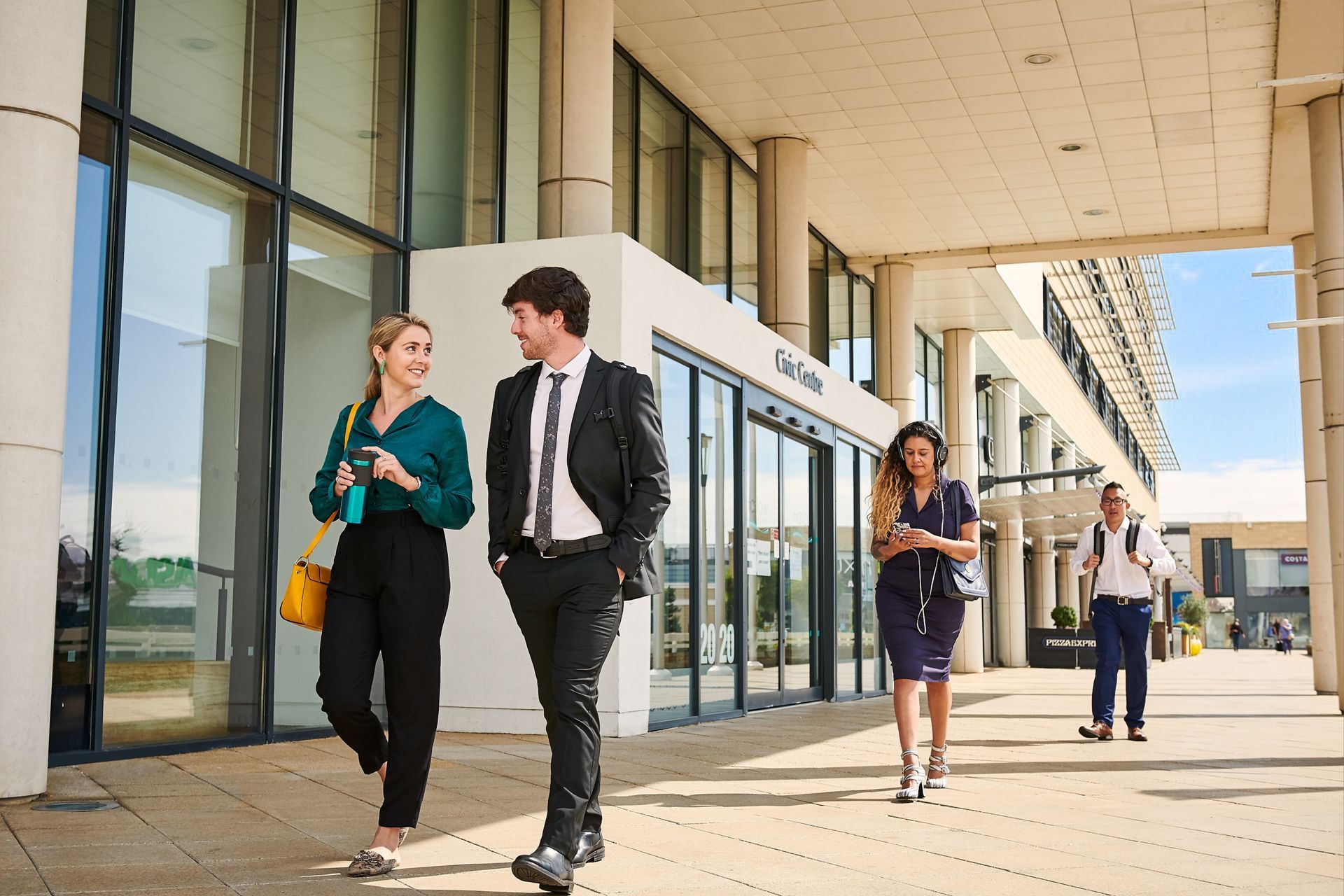 A group of people are walking in front of a building.