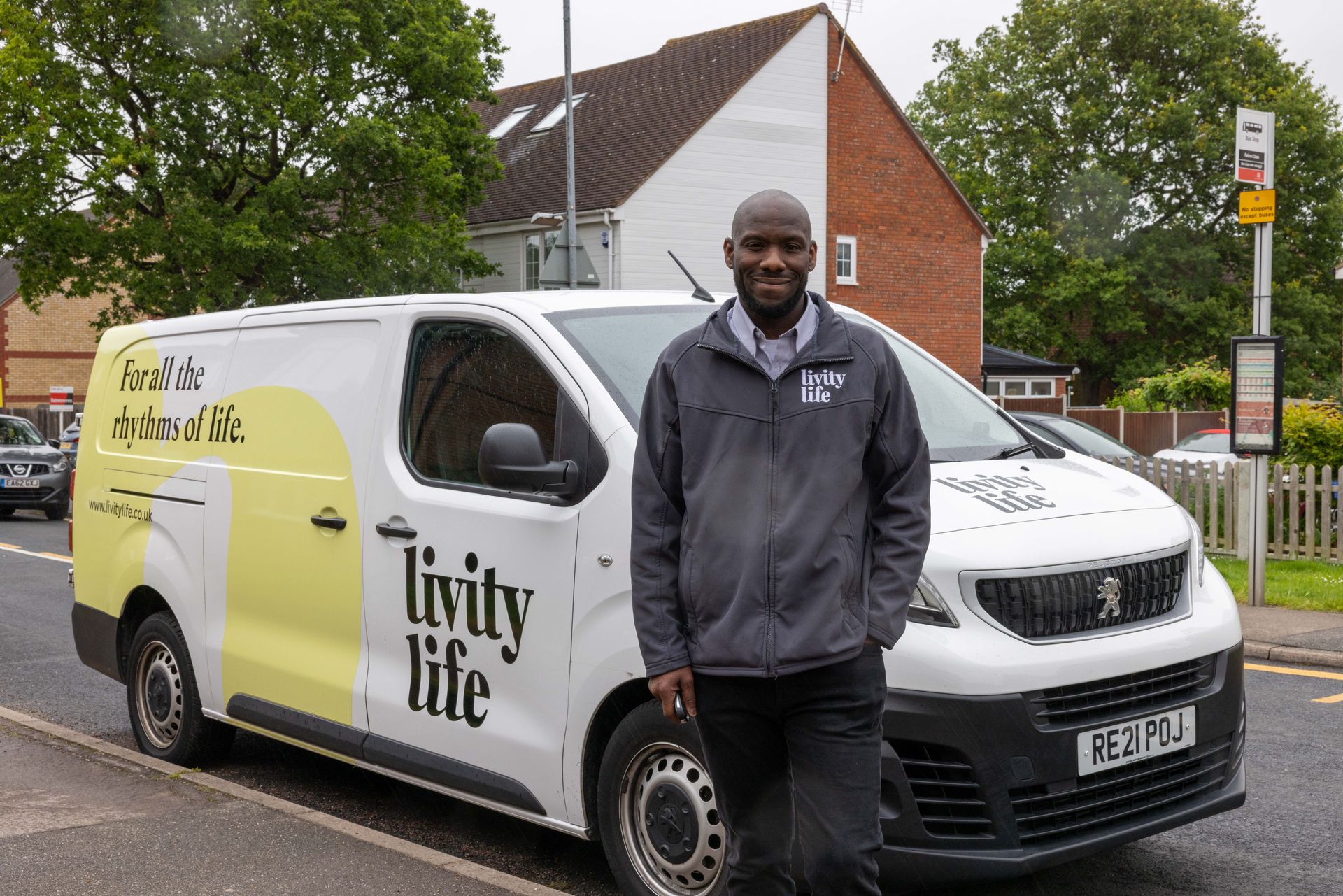 A man is standing in front of a van that says tivity life on it.