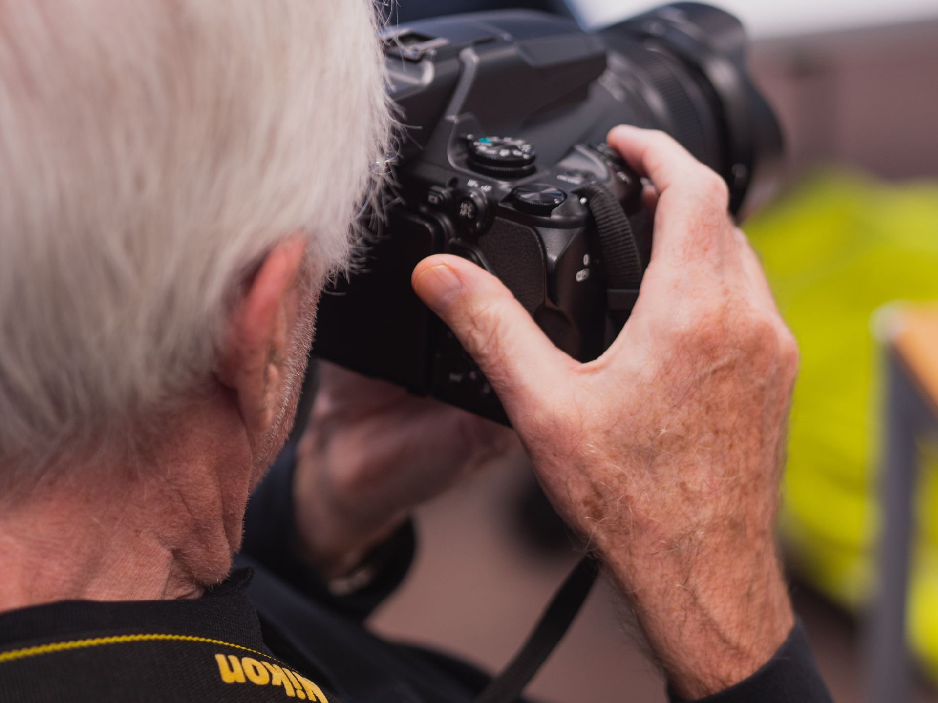 A man taking a picture with a nikon camera