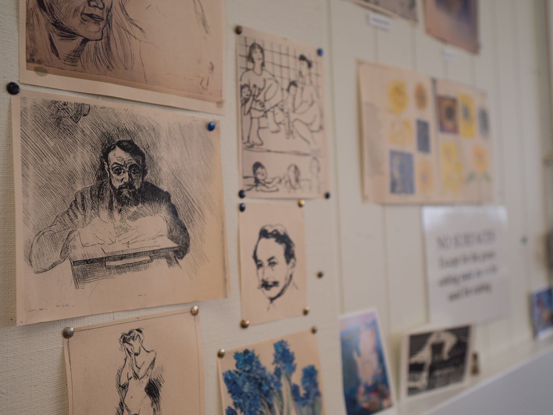 A wall with a bunch of drawings on it