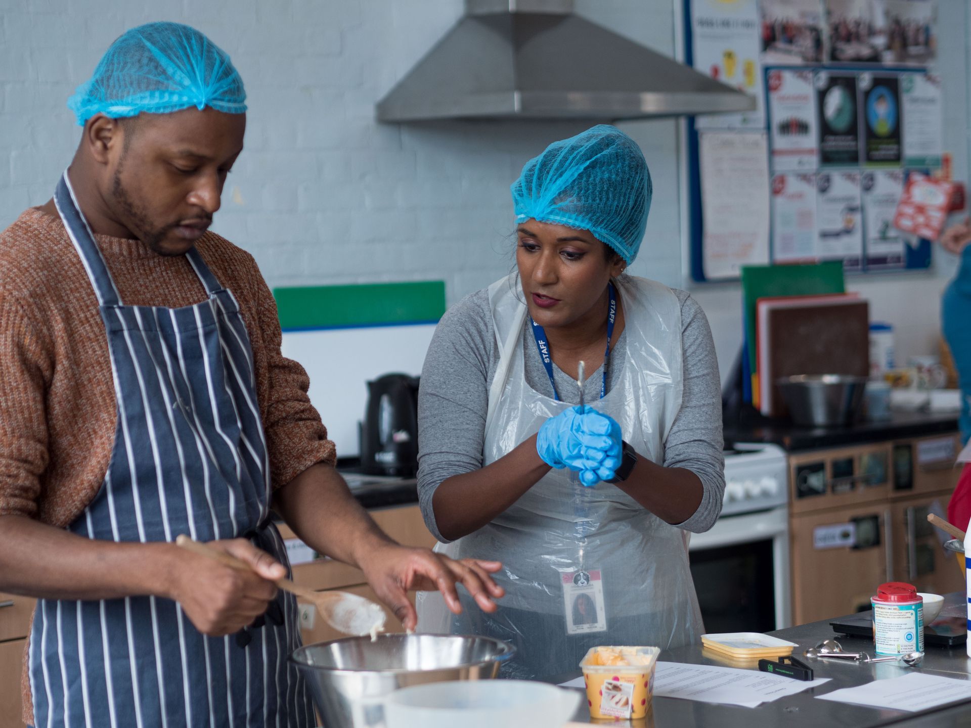 A man and a woman are preparing food in a kitchen.