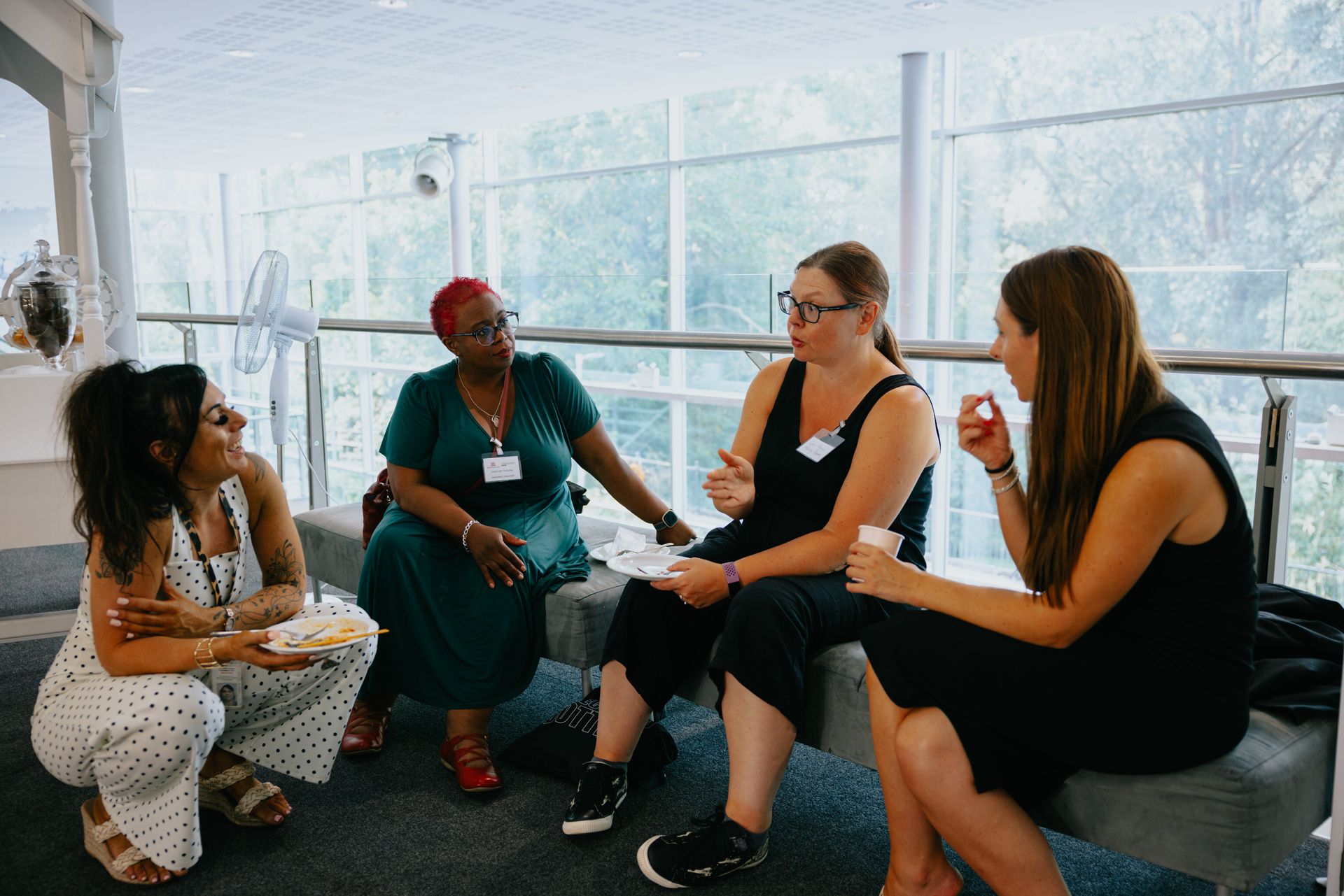 A group of women are sitting in a circle talking to each other.