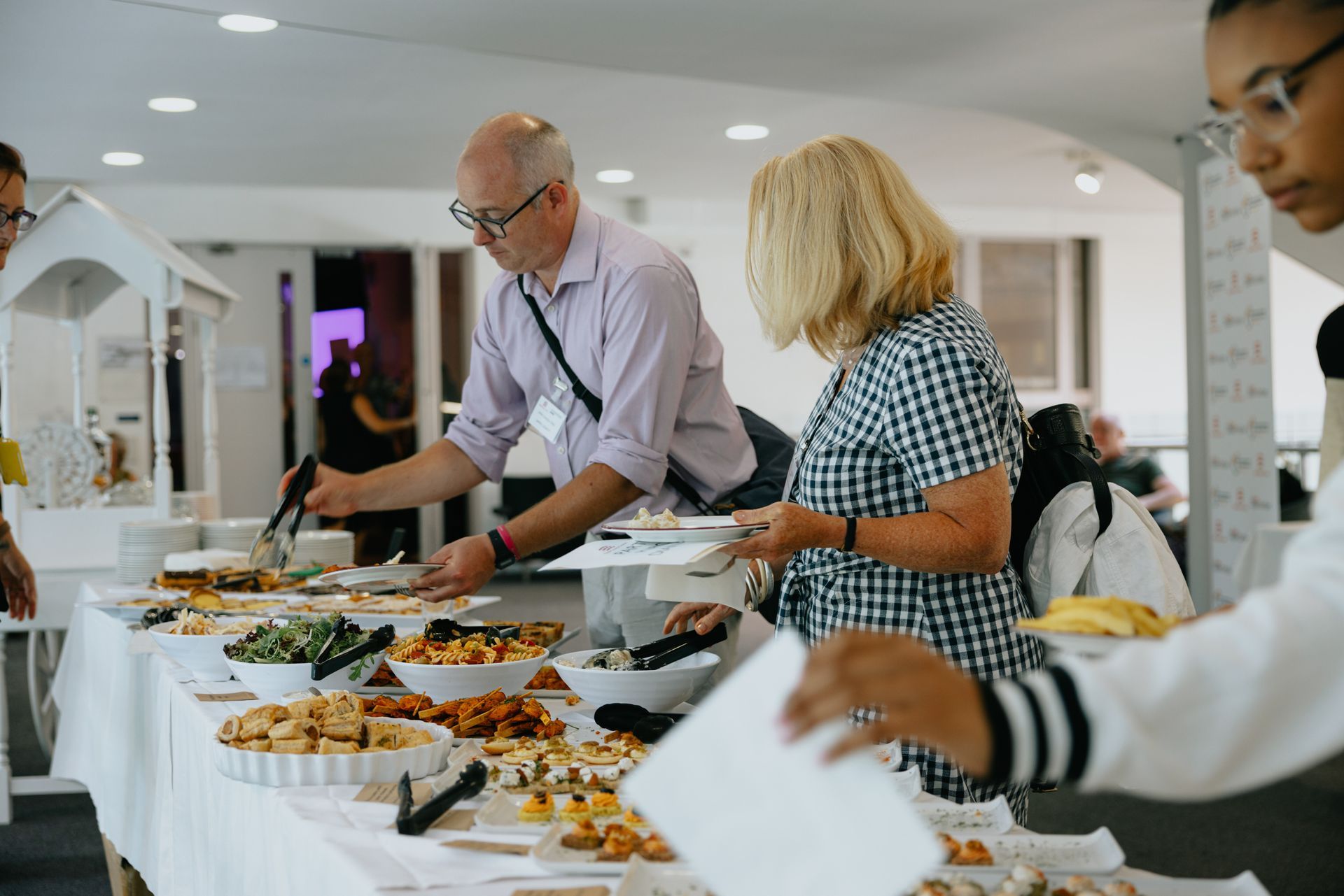 A group of people are standing around a buffet table.