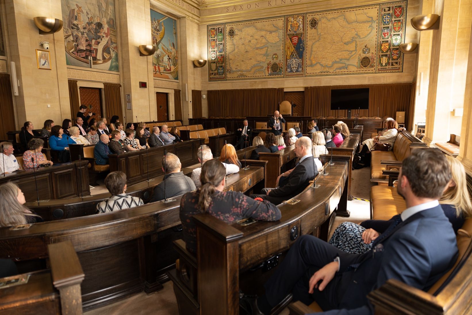 A group of people are sitting in a large room.