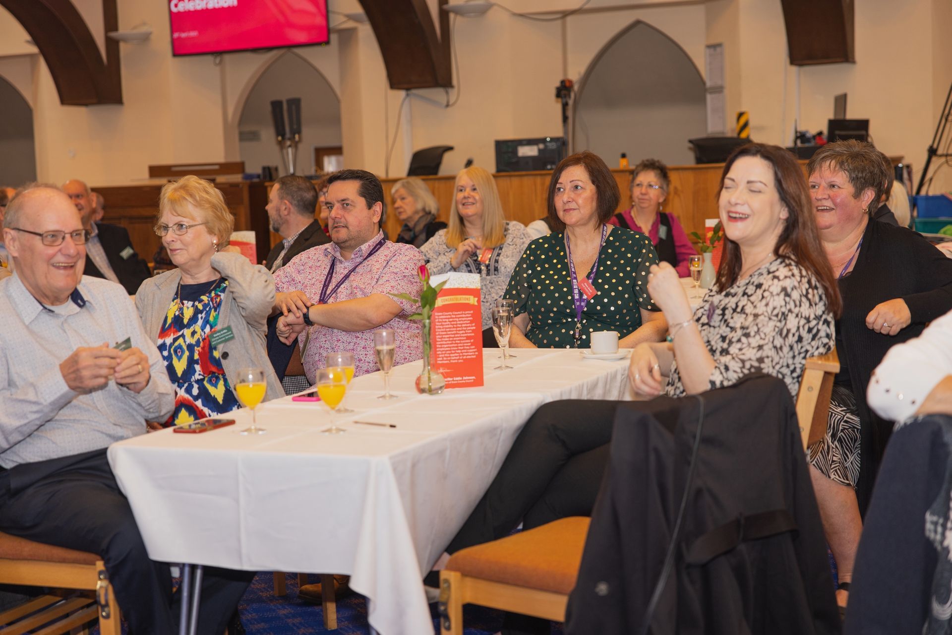 A group of people are sitting at a table laughing.