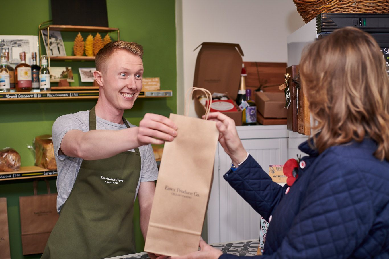 A man is giving a bag to a woman in a store.