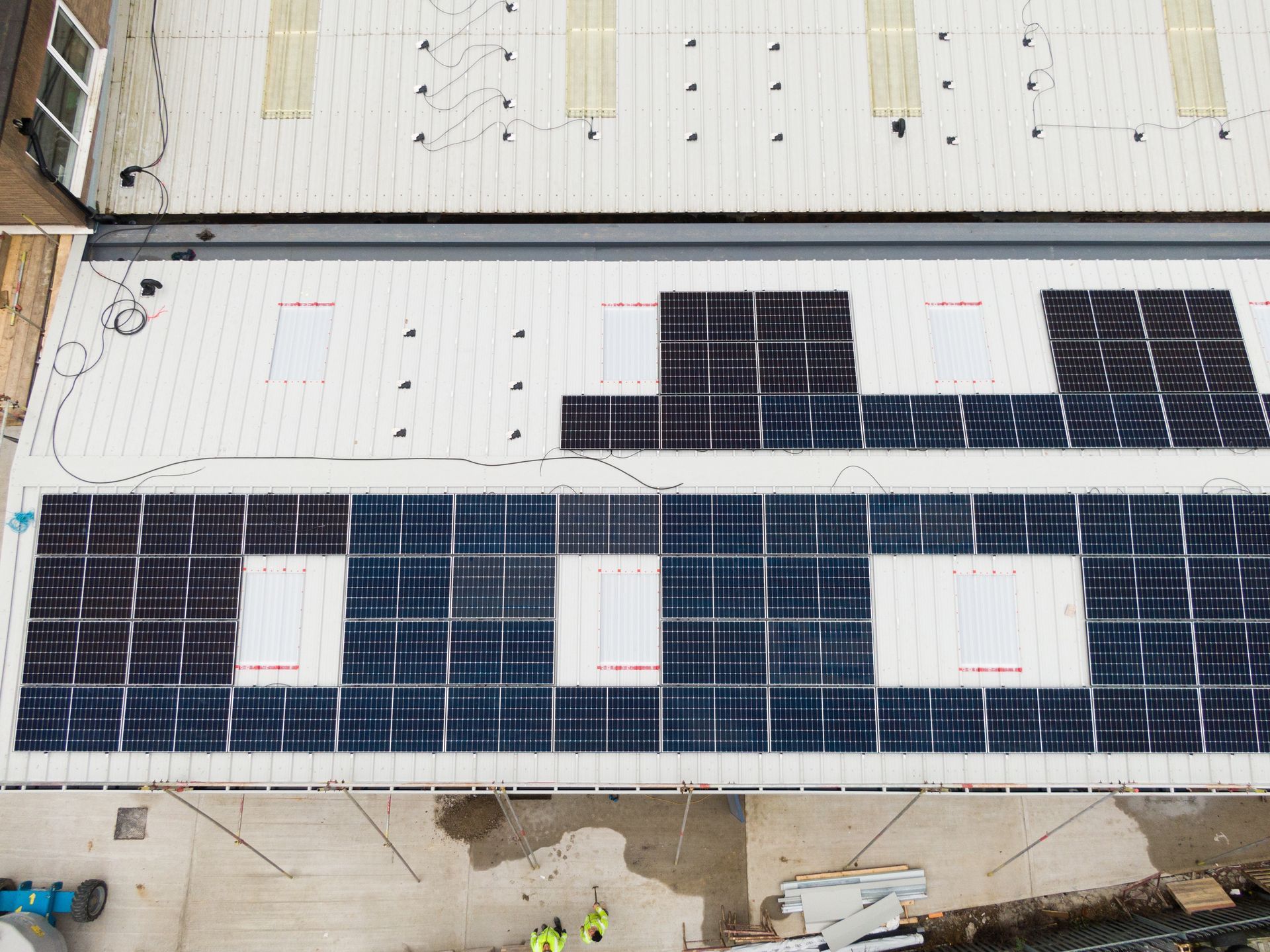 An aerial view of a building with solar panels on the roof.