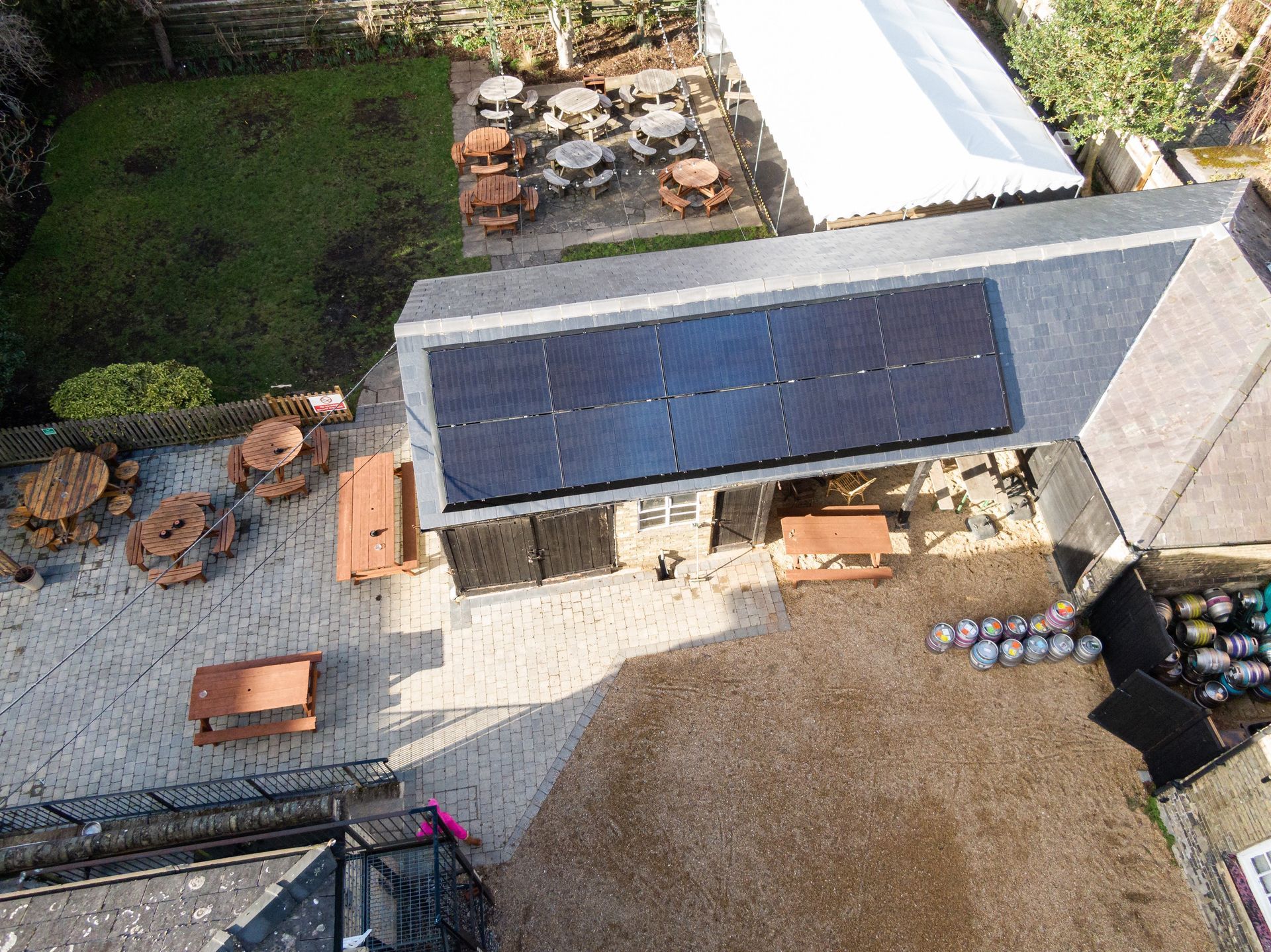An aerial view of a house with solar panels on the roof.