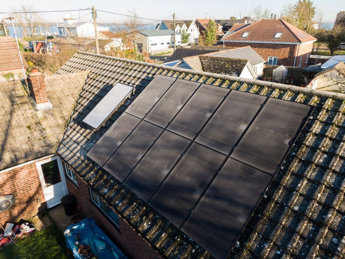 An aerial view of a house with solar panels on the roof.