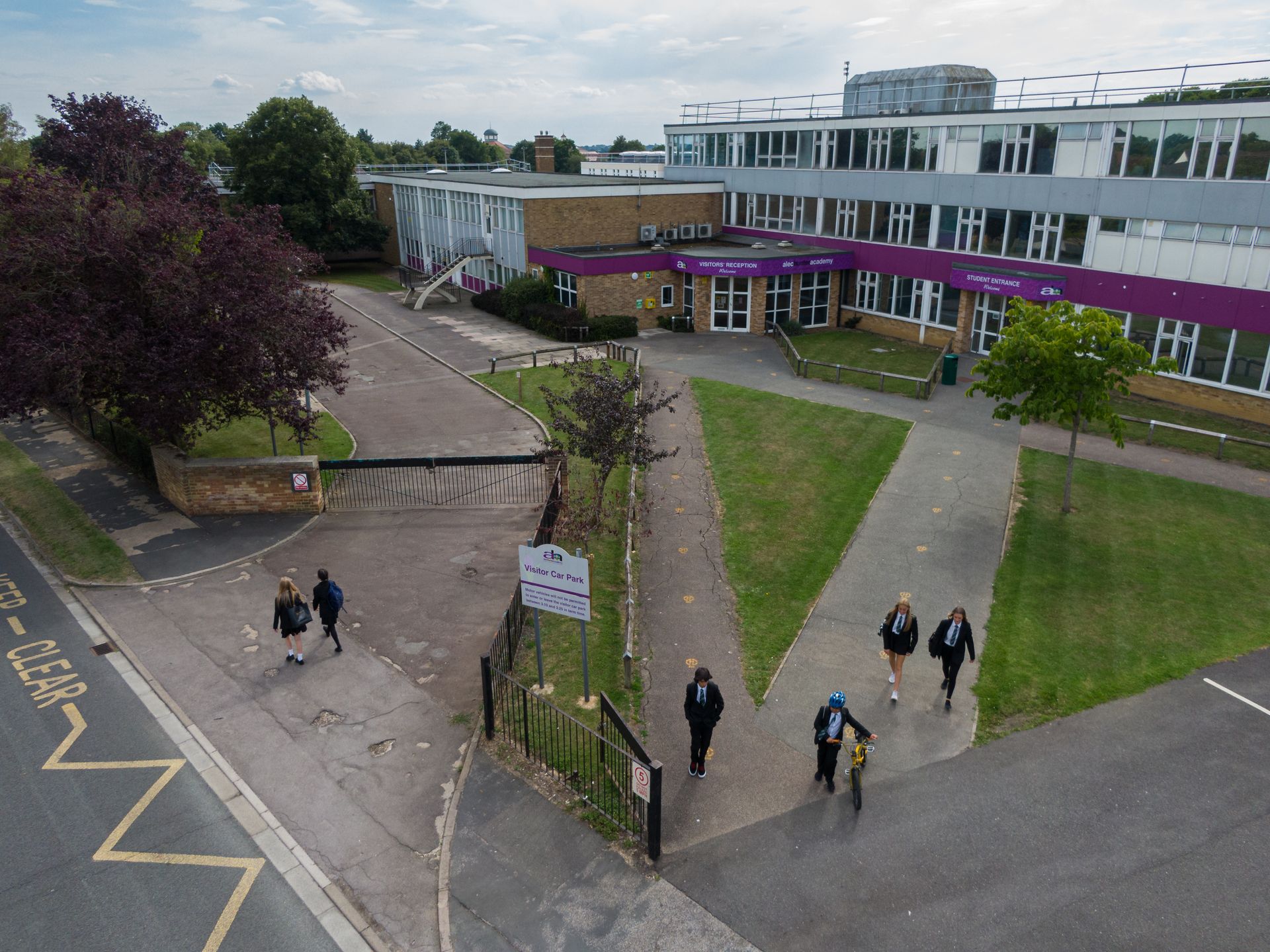 A group of people are walking in front of a large building