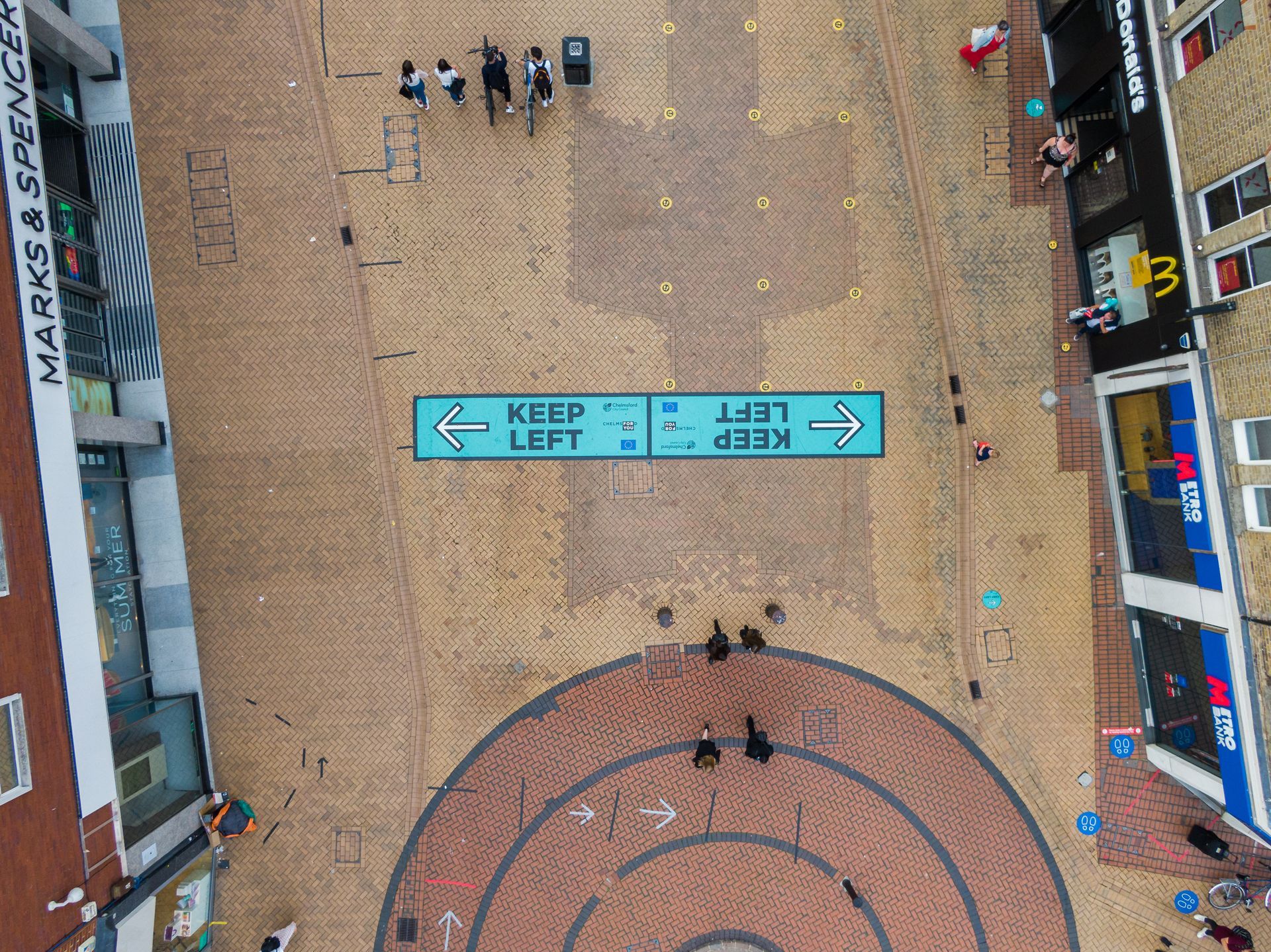 An aerial view of a street with a sign that says keep left