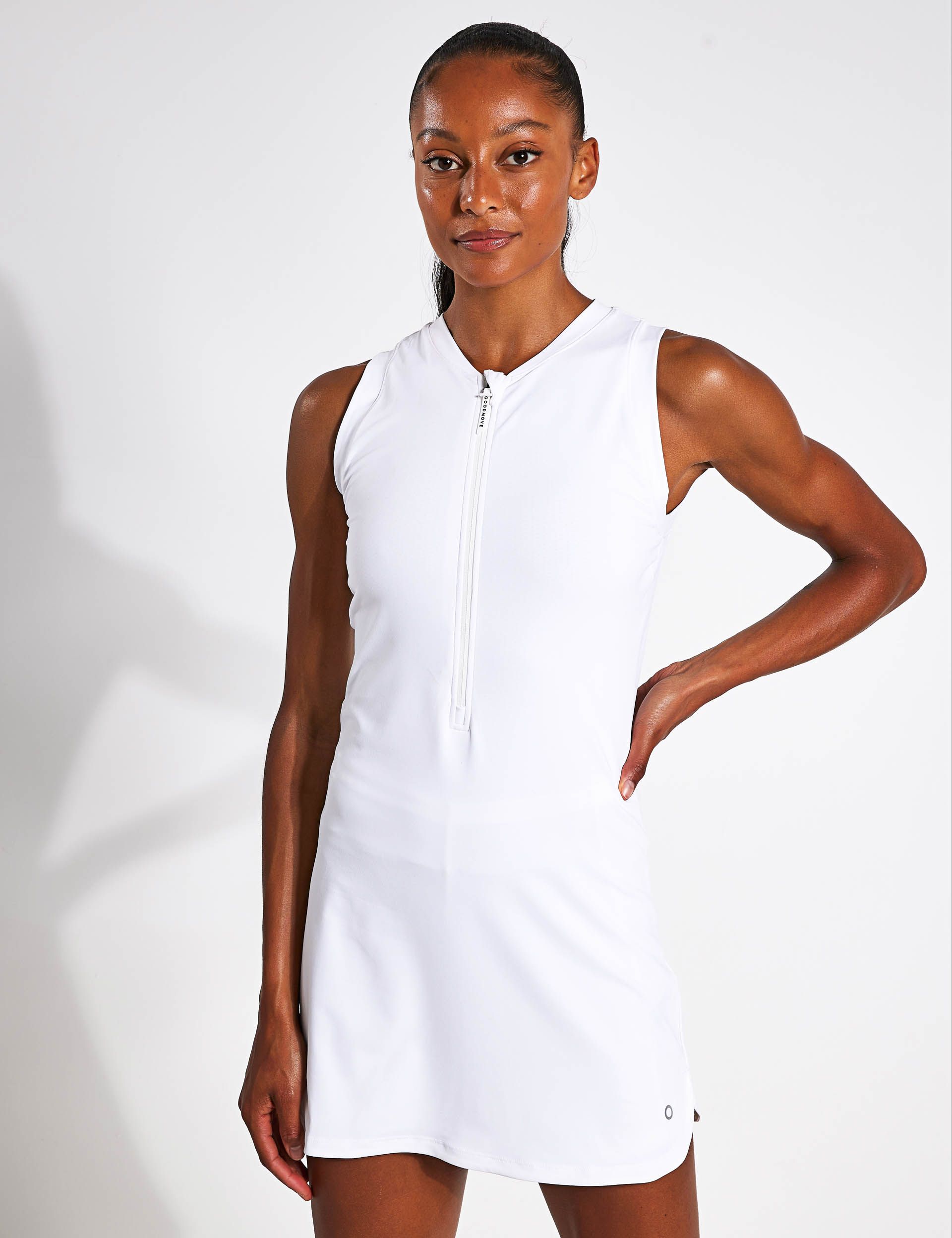 A woman is wearing a white dress with a zipper on the front.