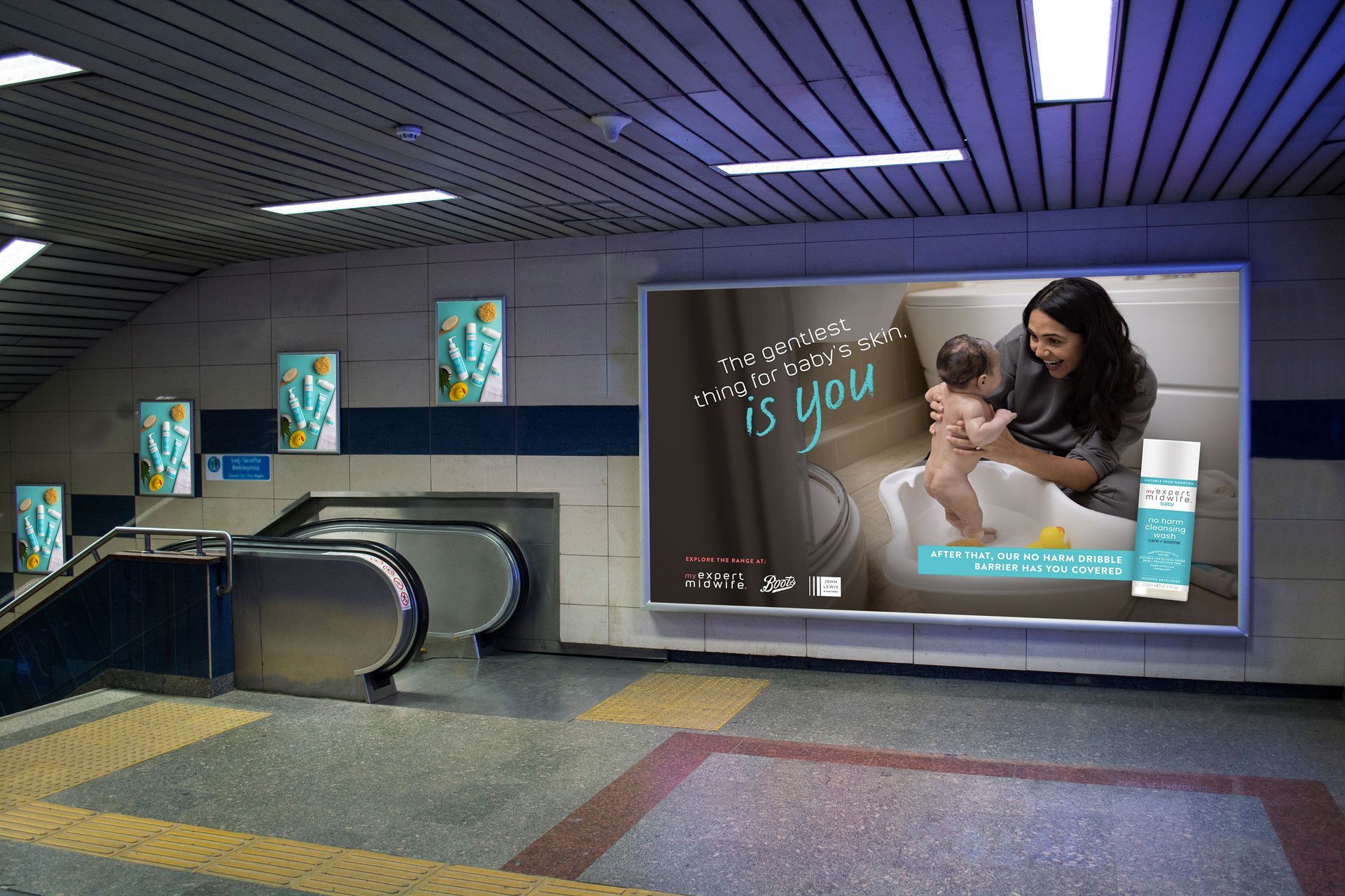 A billboard in a subway station shows a woman holding a baby
