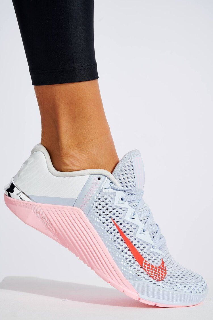 A person wearing a pair of white and pink nike shoes
