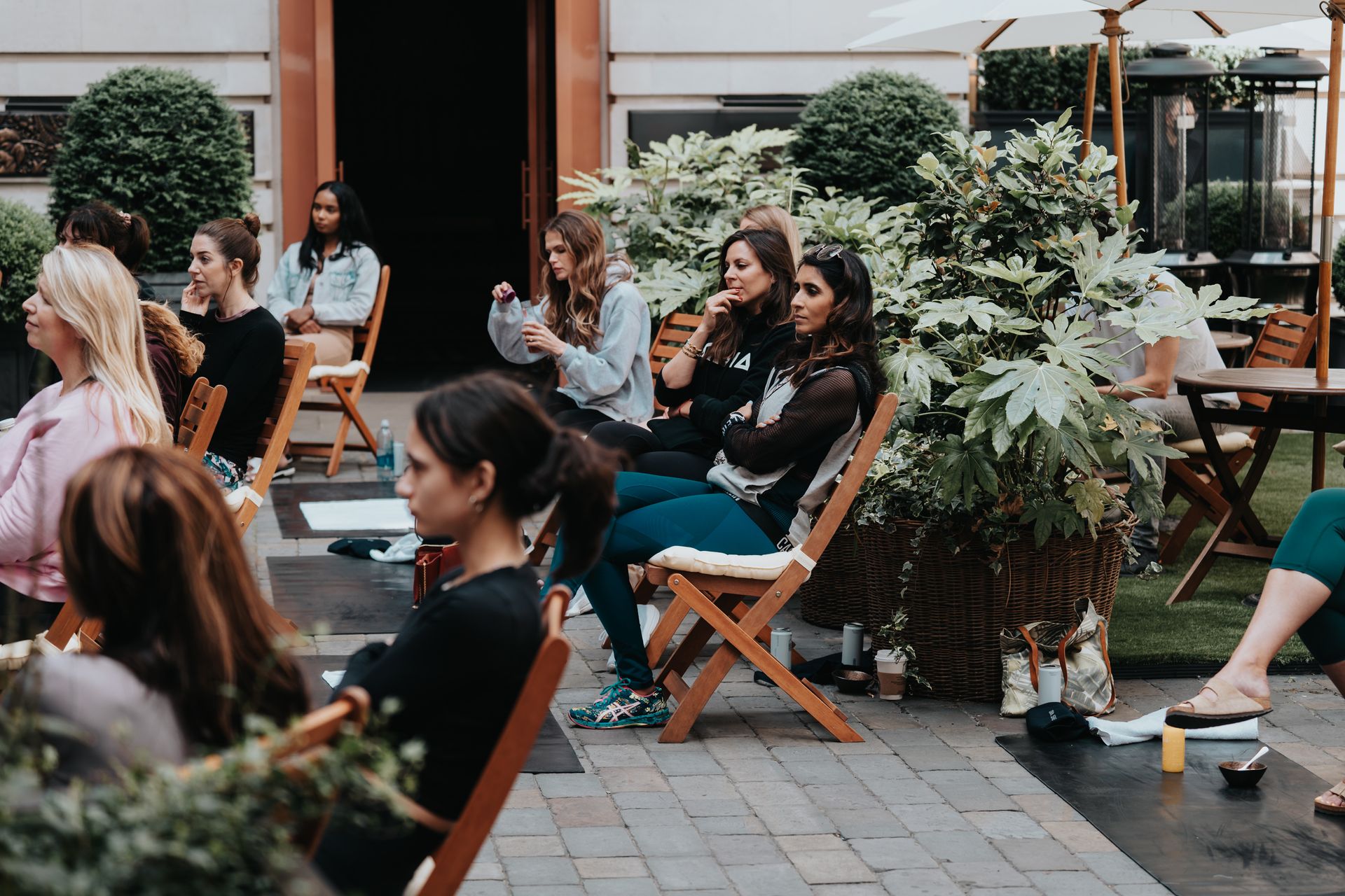 A group of people are sitting in chairs outside of a building.