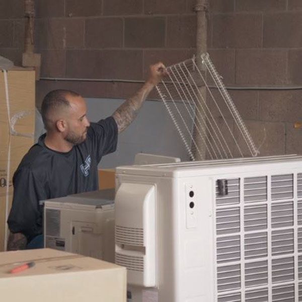 Worker coating wire rack in warehouse