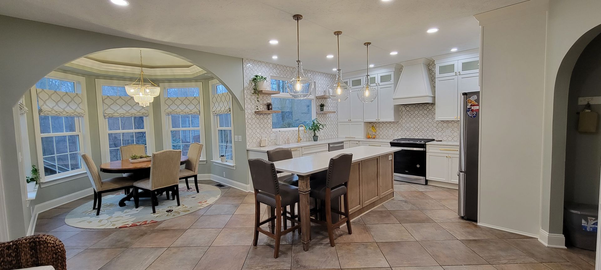 Open-concept kitchen and dining area with a large island and bay window seating.