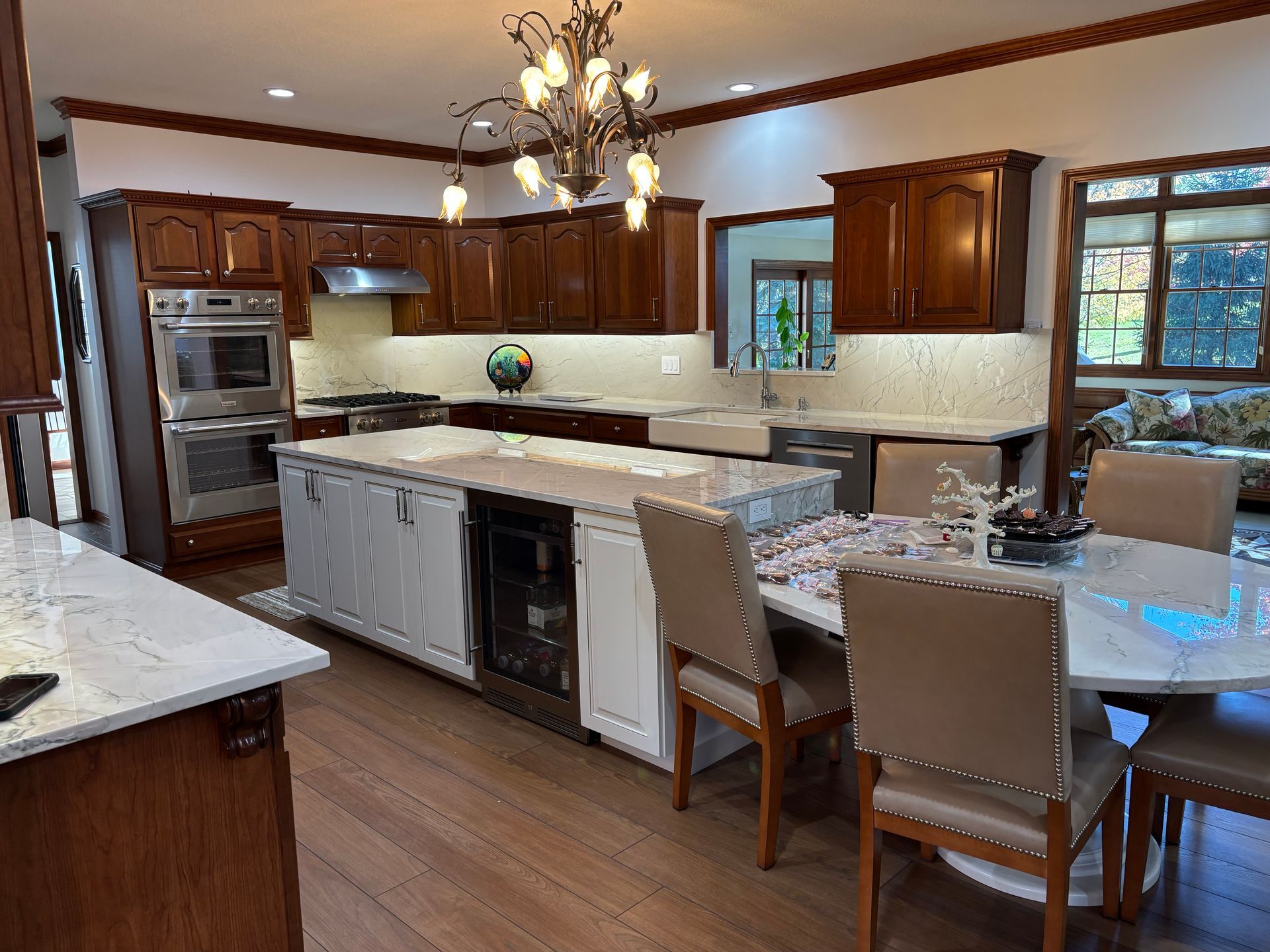 Spacious kitchen with wood cabinets, white countertops, stainless steel appliances, island, and dining area.