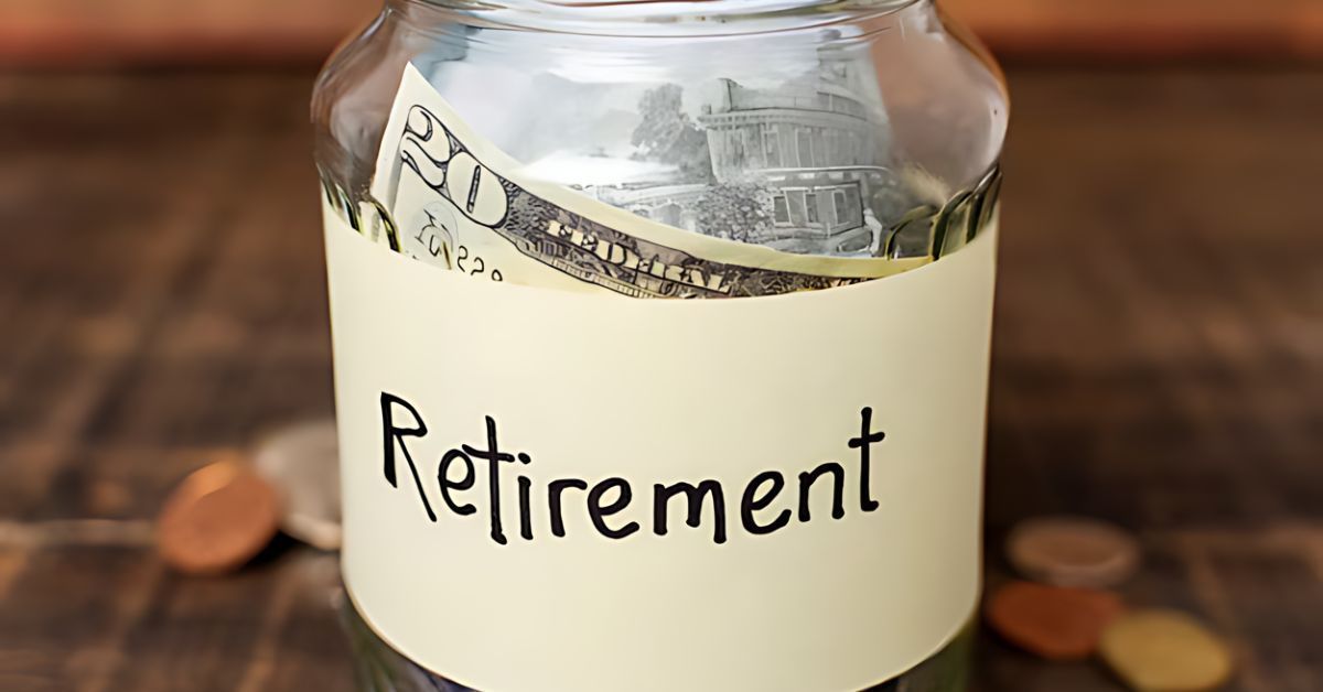 Jar labeled “Retirement” filled with cash and coins on a wooden table.