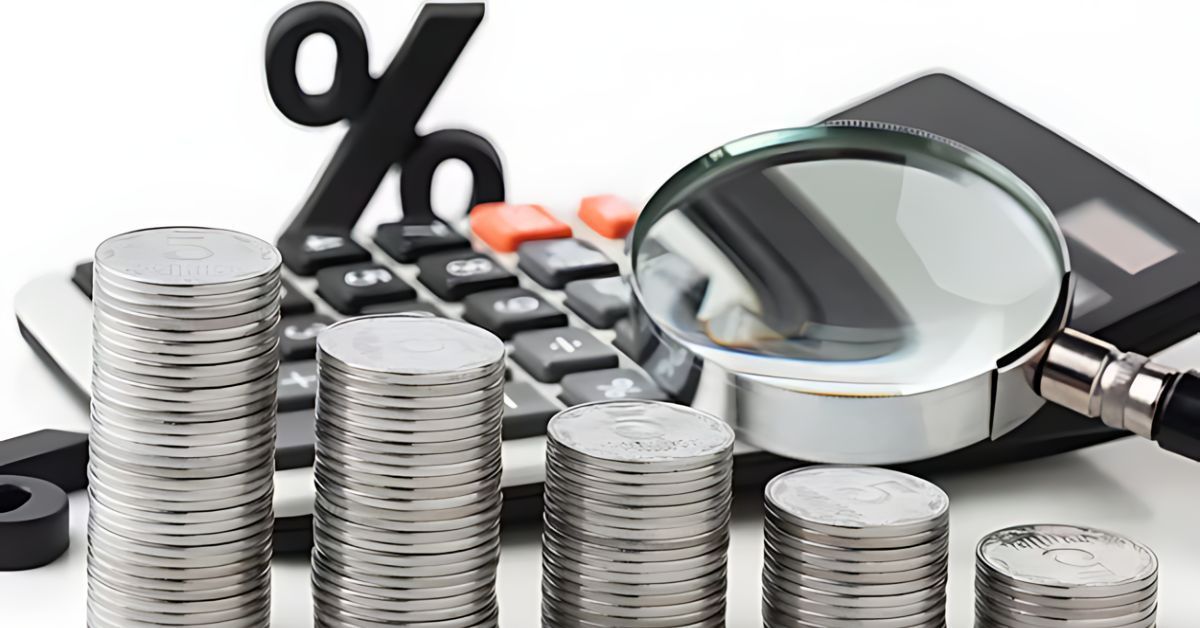 Stacks of coins with a magnifying glass, calculator, and percent symbol, suggesting financial analysis
