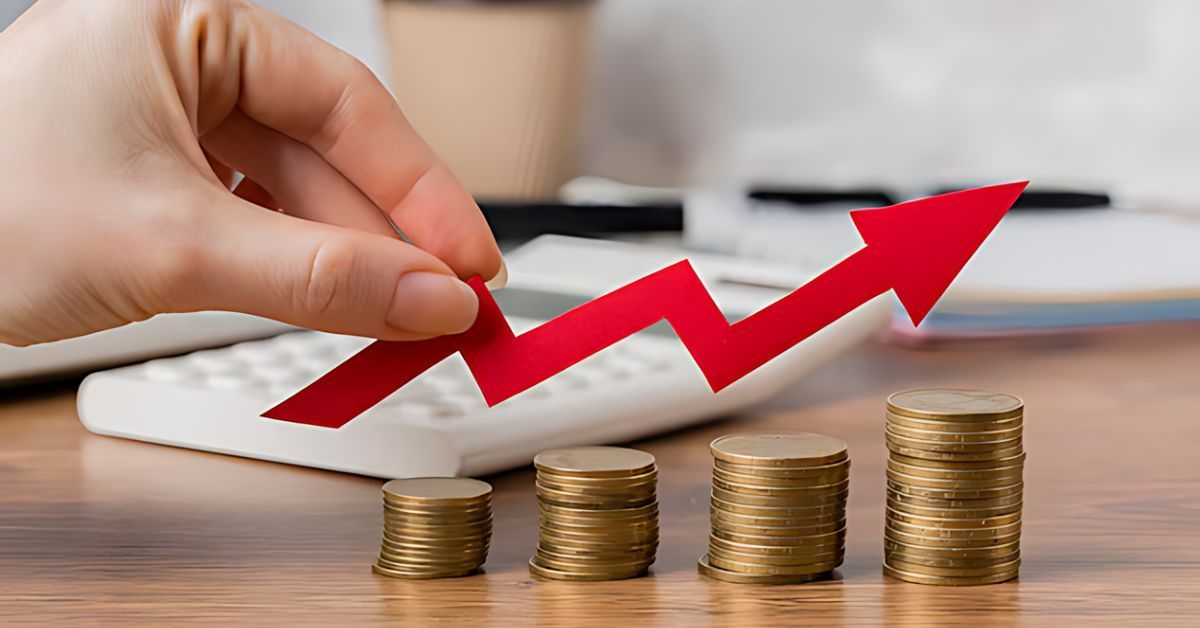 Hand placing a red upward arrow over stacked coins, symbolizing financial growth.