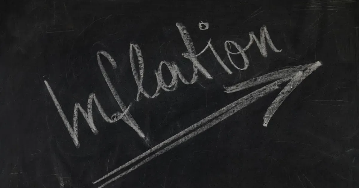 Chalkboard with the word “inflation” written in white chalk and underlined by an arrow.