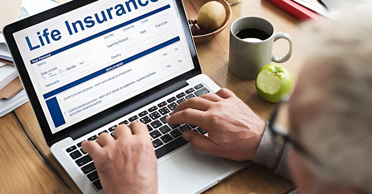Person typing on a laptop showing a life insurance website beside a coffee mug and tennis ball.