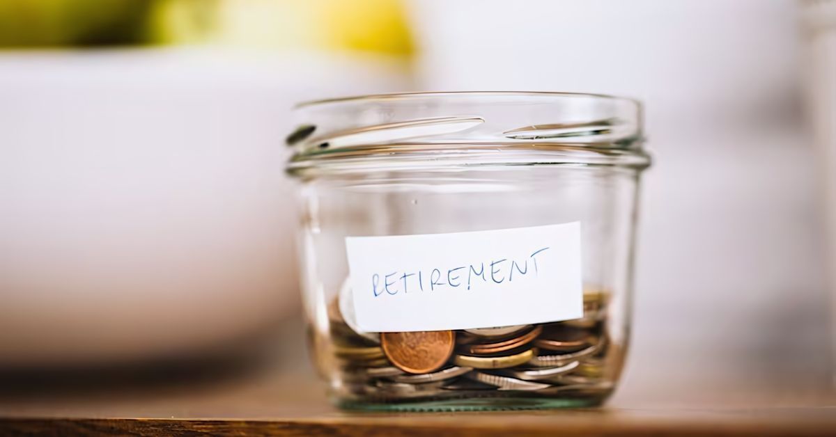 Glass jar labeled “RETIREMENT” filled with coins on a table