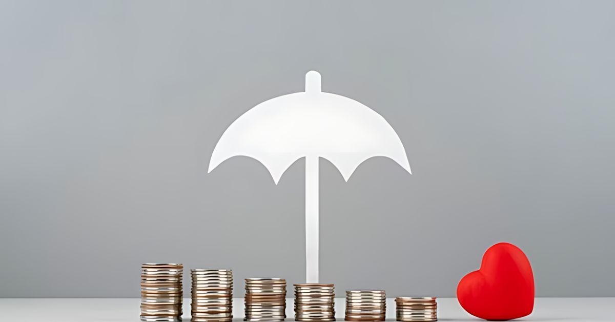 White umbrella sheltering stacks of coins beside a red heart on a gray surface