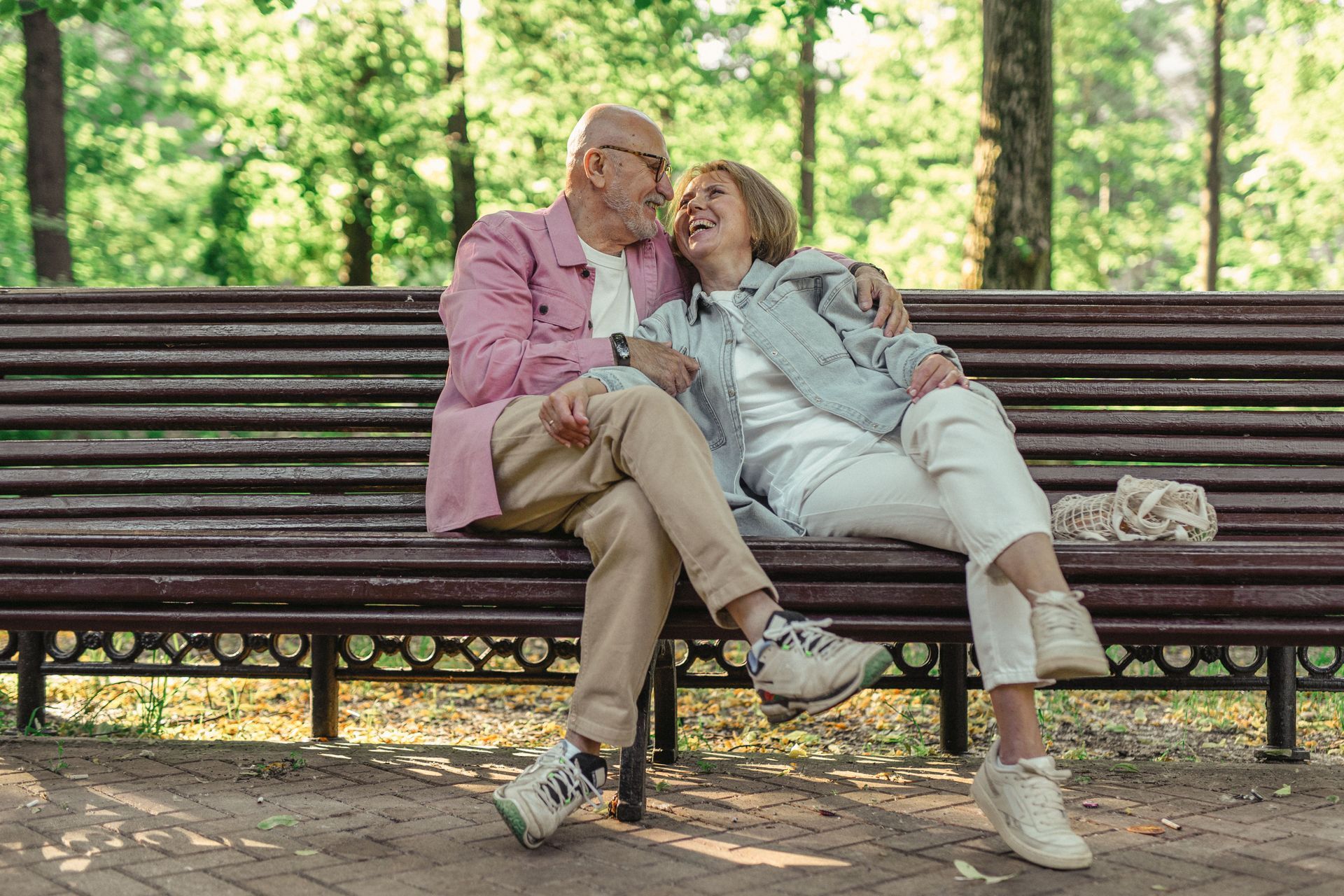 Two people sitting on a dock, smiling and drinking by sparkling water