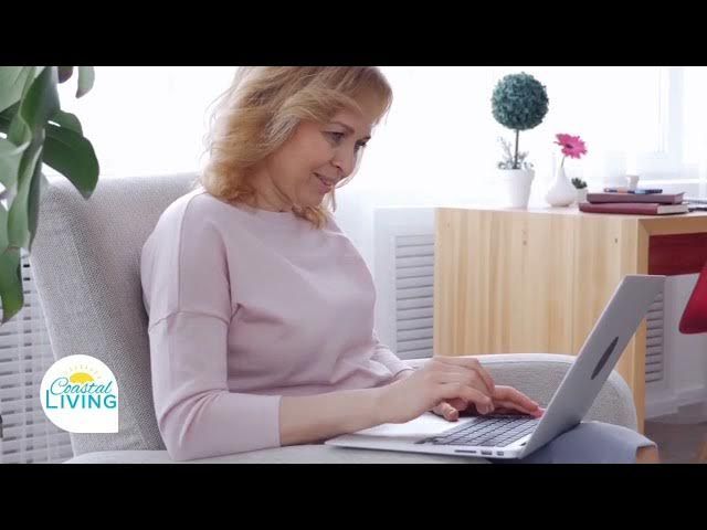 Woman using a laptop on a couch in a bright living room