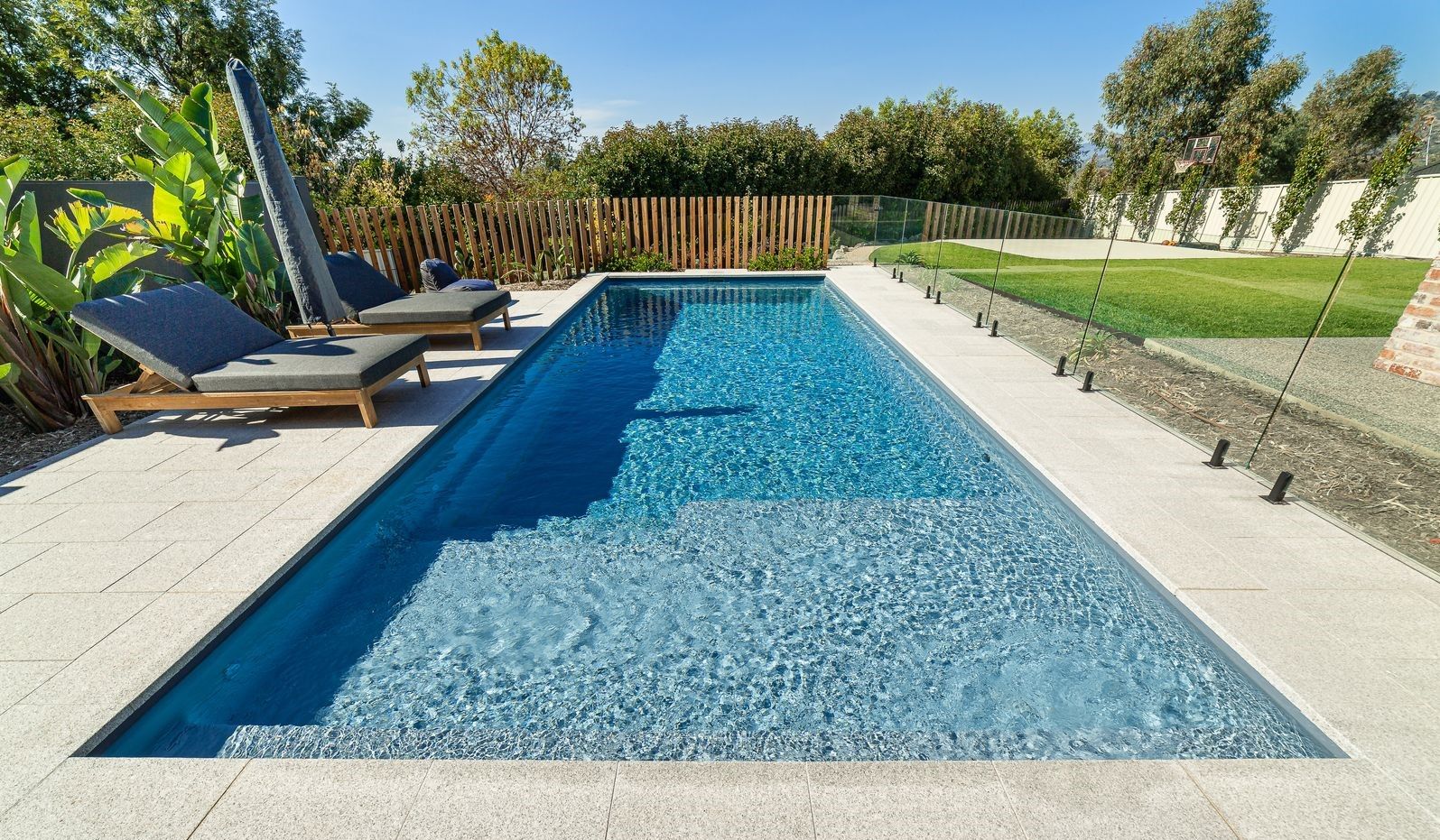 There is a Large Swimming Pool in the Backyard of a House — Gibson Family Pools Pty Ltd In Port Macquarie, NSW