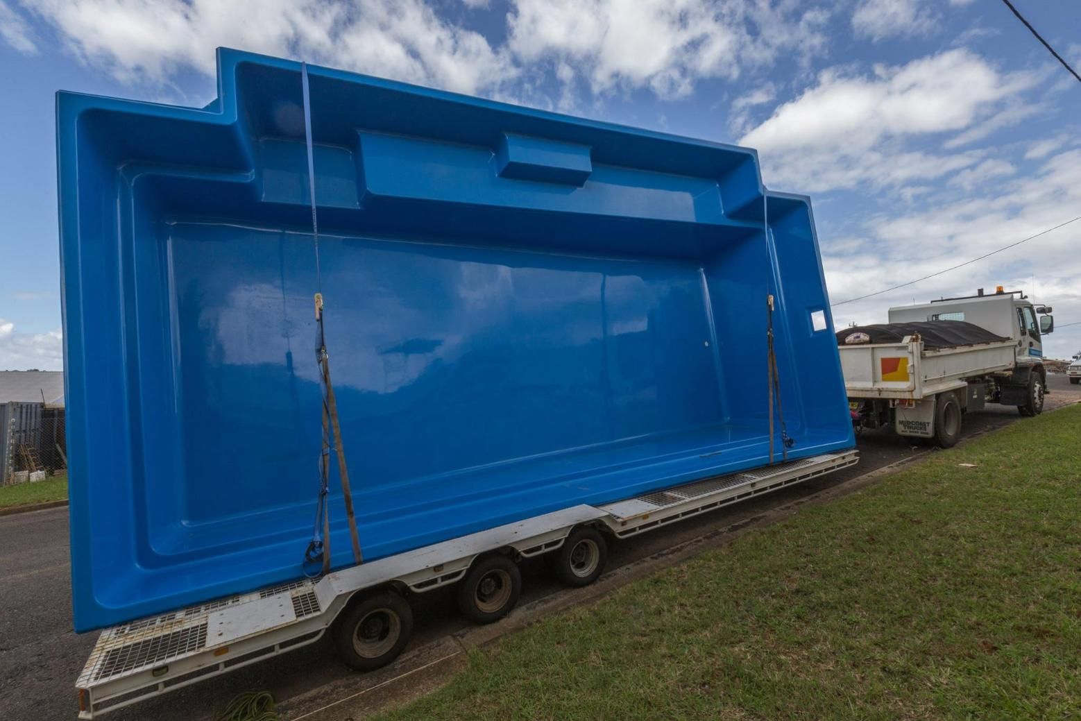 A Large Blue Swimming Pool is Being Transported on a Trailer — Gibson Family Pools Pty Ltd In Nambucca Heads, NSW