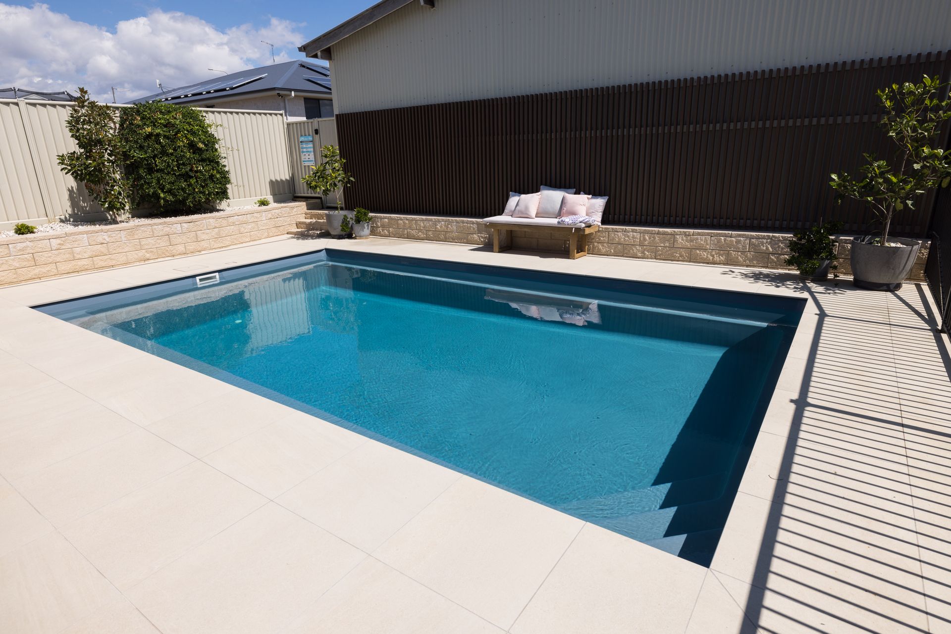 There is a Large Swimming Pool in the Backyard of a House — Gibson Family Pools Pty Ltd In Taree, NSW